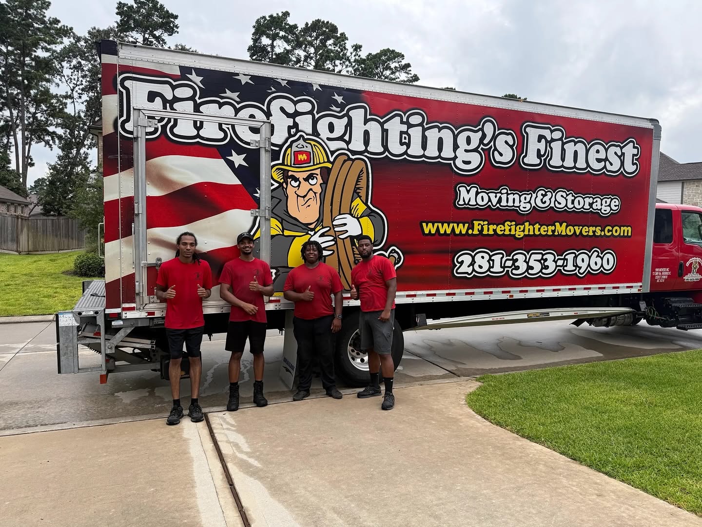 A crew of four professional movers from Firefighting's Finest Moving & Storage giving a thumbs up in front of their branded moving truck, ready for a residential move in Grapevine, TX.