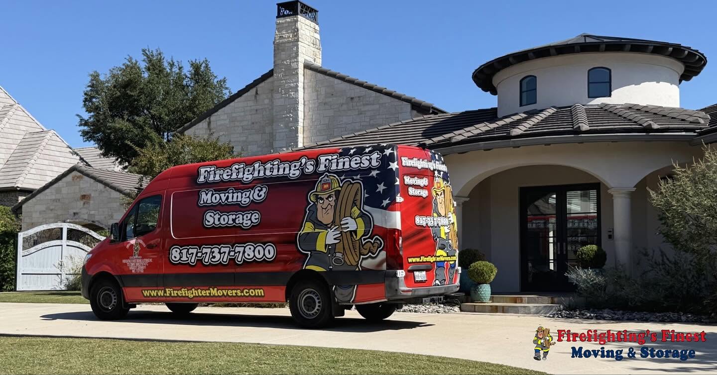 A red Firefighting's Finest Moving & Storage van parked in the driveway of a large modern home, ready to provide professional residential moving services in Denton, TX.