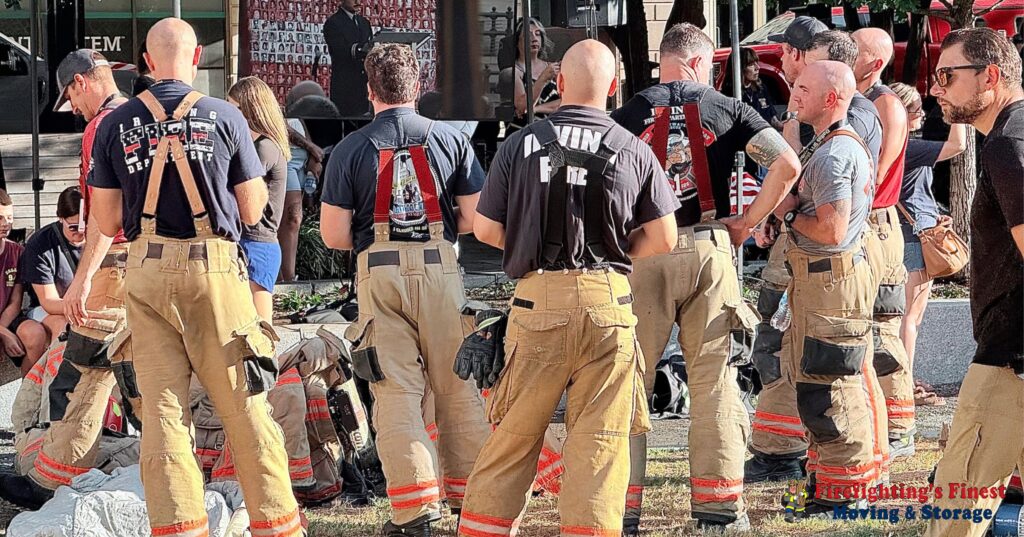 Group of off-duty firefighters wearing tan turnout pants and Irving Fire Dept t-shirts standing together at an outdoor event, representing Firefighting's Finest Moving & Storage in McKinney.