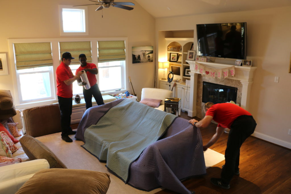 Firefighting’s Finest Moving & Storage movers carefully wrapping a couch for their moving services in Fort Worth, Texas