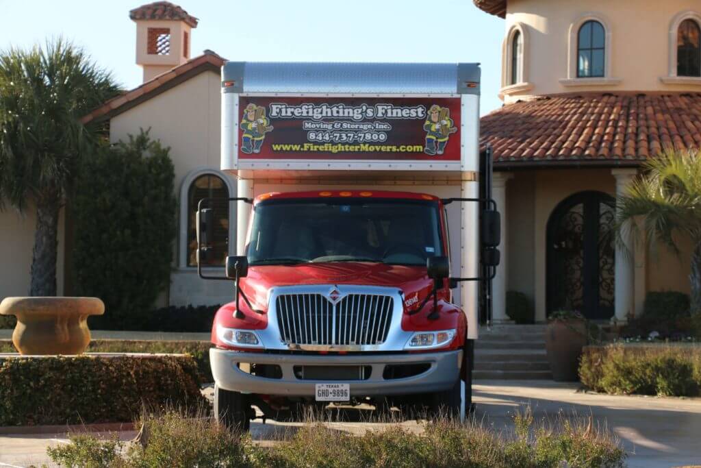 Firefighting Finest Moving & Storage truck parked in front of home for Moving Service in Cypress, TX