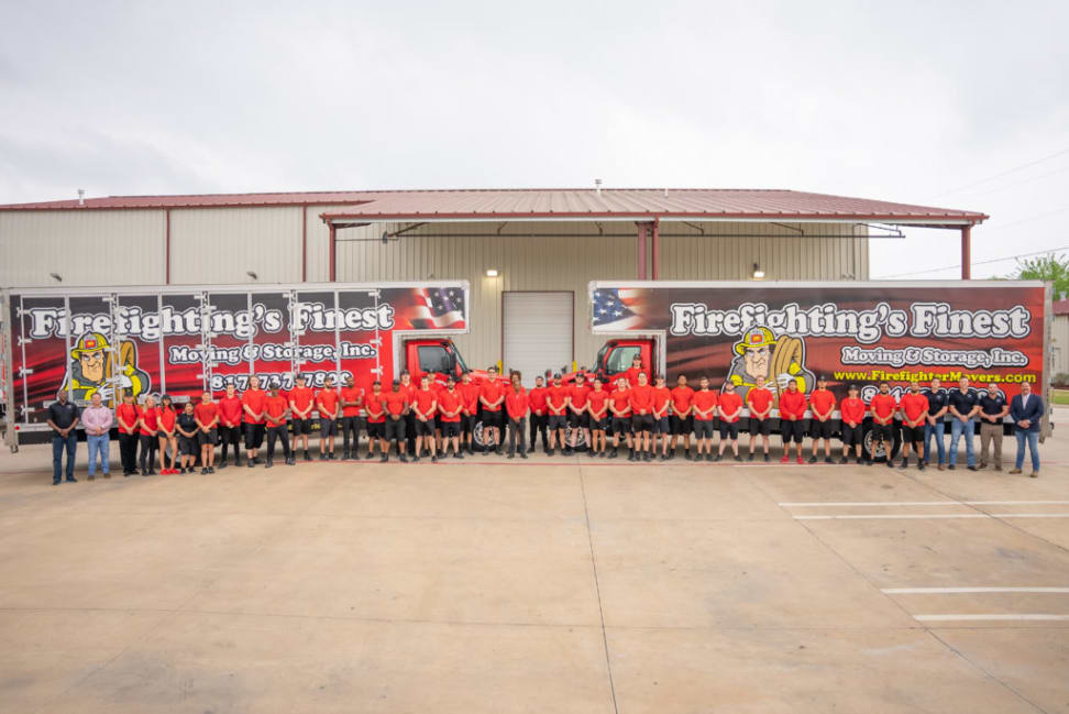 Firefighting’s Finest Moving & Storage dedicated team outside warehouse with branded moving trucks in the background