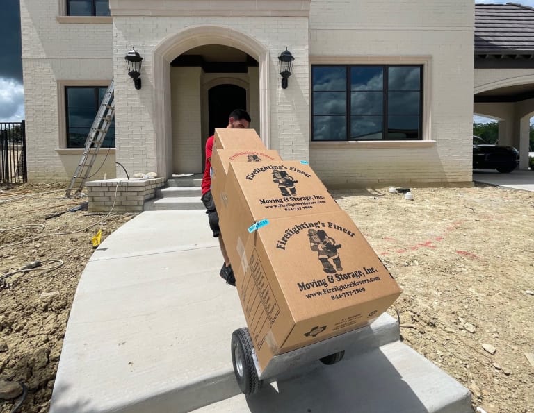 A mover with a load of boxes going into a new home