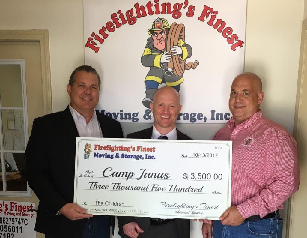 Firefighting's Finest Moving and Storage team members holding a donation to Camp Janus in Texas